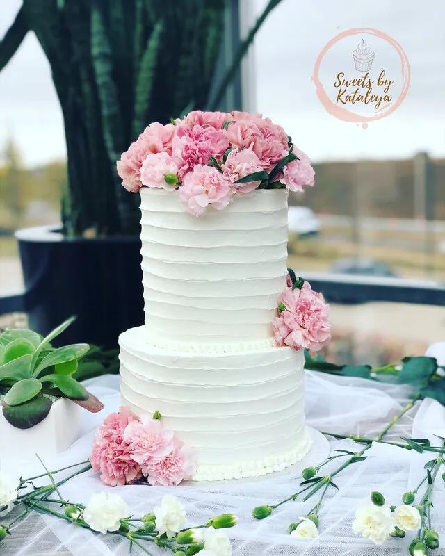 White tiered wedding cake with pink flowers
